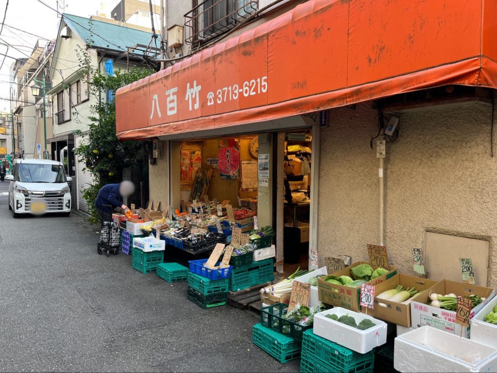 オレンジ色のひさしが目印の「八百竹」。旬の野菜や果物がお手頃価格で販売されていました。